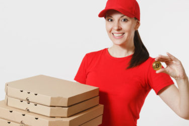 a pizza deliverer holding the bitcoin symbol